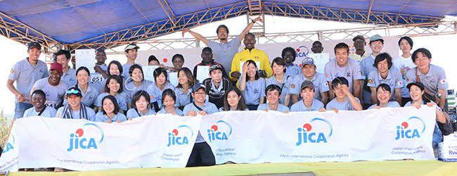  apanese volunteers who participated in the run pose with s avid atende and s mbrose ashobya asnd other officials after the run