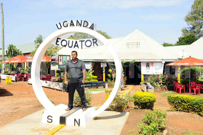   tourist poses for a photo at the ganda quator in ayabwe pigi district