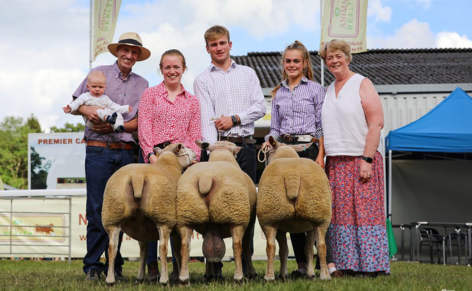 Charles Sercombe holding his grandson, Jack with Victoria, William, Grace and Helen at the Royal Welsh Show 2024 and their winning Group of Three Charollais