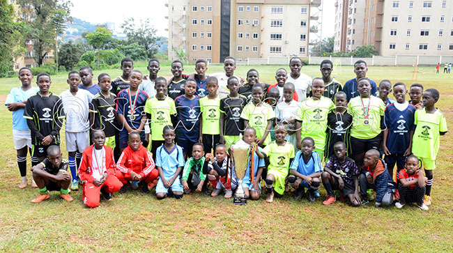  he occer cademy players  pose with the ubai inter up that their nder11  team won recently in ubai at their training ground in amwokya