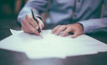 File photo: a worker signs a contract