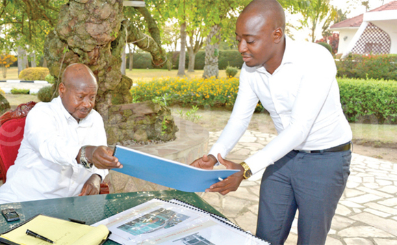Omugagga Kiggundu ng’alaga Pulezidenti Museveni pulaani y’e Nakivubo gye yamutwalira gye buvuddeko. Ku ddyo kye kiwandiiko ekikkiriza Ham okuzimba Omugagga Kiggundu ng’alaga Pulezidenti Museveni pulaani y’e Nakivubo gye yamutwalira gye buvuddeko. Ku ddyo kye kiwandiiko ekikkiriza Ham okuzimba