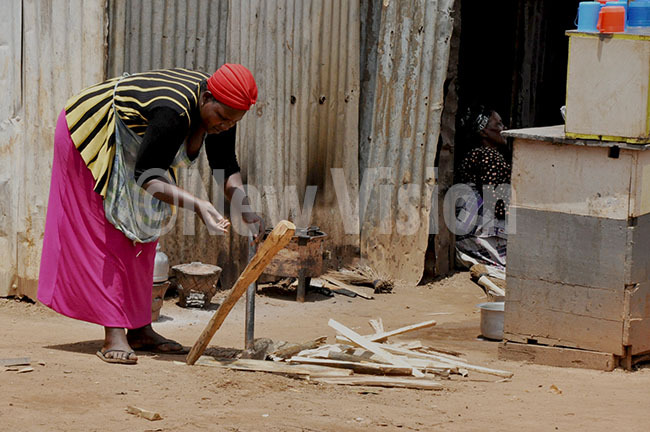   lady chopping firewood to be used for preparing food for her customers and evening pourage which does as her business for living and is done on a daily basis in nyanama ampala on the 1st ovember 2019 hoto by immy uta