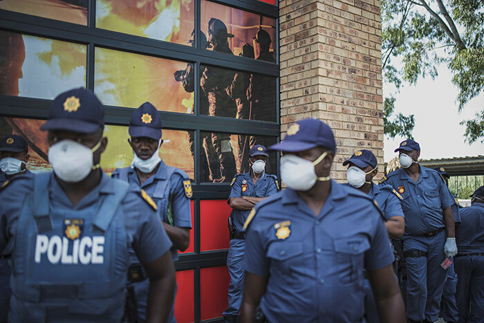  embers of the outh frican olice ervices  wearing a mask amid concerns over the spread of the 19 coronavirus gather ahead of a volunteer drive in the densely populated iepsloot township in ohannesburg on arch 21 2020 olunteers distributed soap bars and informative leaflets to the resident in a move aimed to bolster awareness of the risk of poor hygiene    