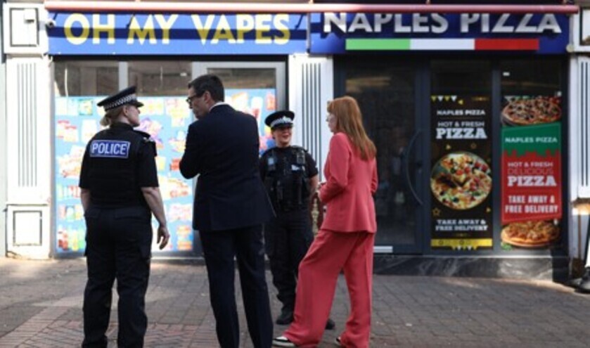 Prime Minister Andy Burnham and local government secretary Angela Rayner (right) speak with police officers outside a vape shop in Ilkeston, Derbyshire, to discuss practical action to give people a say over the future of their high streets, including a crackdown on vape shops © PA Images/Alamy Stock Photo