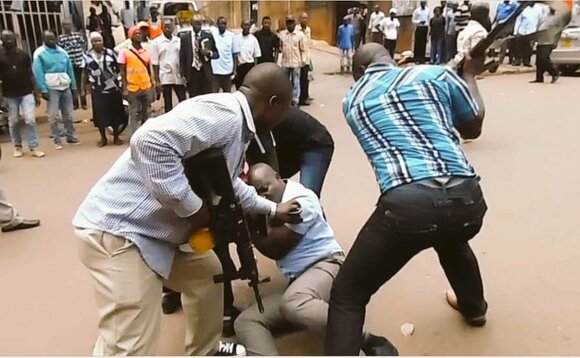 Abaserikale nga batulugunya Kawooya bwe baabadde bamukwata Abaserikale nga batulugunya Kawooya bwe baabadde bamukwata
