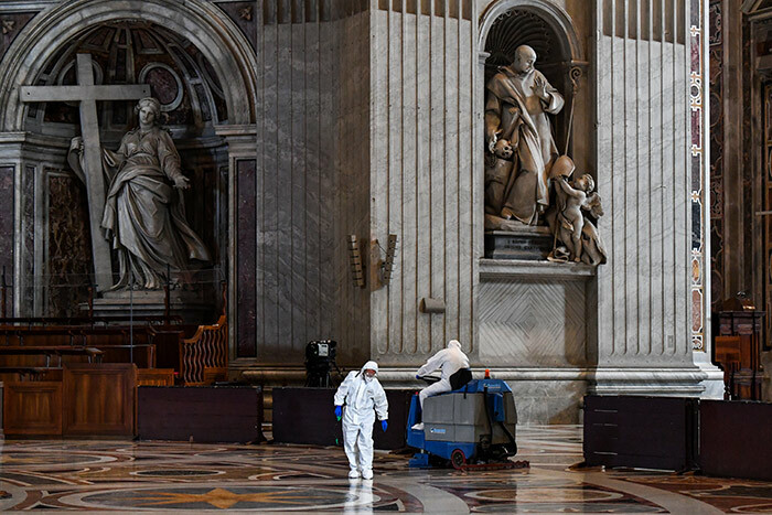   man wearing protective overalls and mask sprays sanitizer as another drives a floor cleaning machine during the sanitation of t eters asilica in he atican on ay 15 2020 during the lockdown aimed at curbing the spread of the 19 infection caused by the novel coronavirus hoto by lberto   