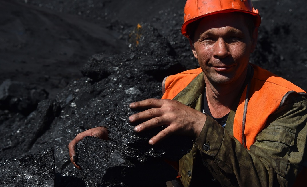 An excavator operator with coal at the Neryungri open pit of the Yakutugol company