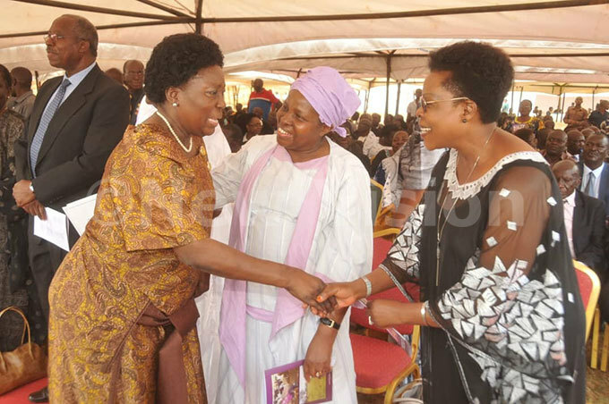  he peaker of arliament ebecca adaga 2nd left greeting inister etty amya right at a funeral service for the ate ishop yprian amwoze at yabazinga tadium  