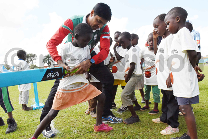 mans jay alcheta helps a young girl with her batting hoto by palanyi sentongo