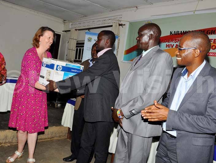  he deputy head of rish id ine enise handsover a printer to oroto district leader as the  country director itus wesige right looks on during the aramoja regional  stakeholders forum hoto by rancis morut