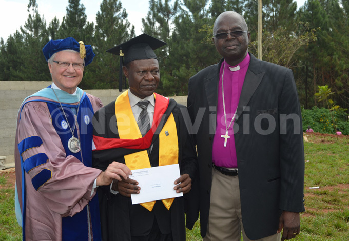 eter eague  hands over the rchbishop enry uke rombi cash prize to oseph usaalo as the rchbishop looks on