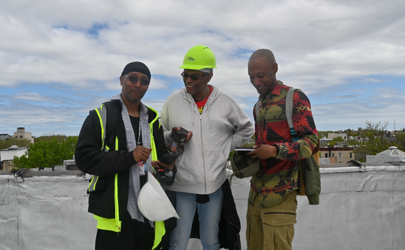 From left, Robert Clark, Que Cunningham and Jevon Rock, trainees in BlocPower's Civilian Climate Corps program, on the roof of a Brooklyn apartment after completing a practice energy audit. Credit: CJ Clouse