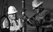 Perth, Western Australia, oil and gas workers installing flowline and production tubing into a well on a small rig.