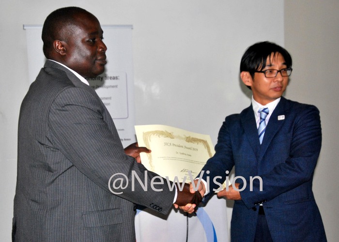  r odfrey sea irector of ational rops esources esearch nstitute in amulonge  receiving a certificate from the enior epresentative apan nternational cooperation gency  akayuki chiyama during the  presidential award