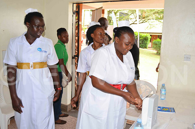 urses from ubaga ospital washing their hands from a hand sanitiser during the function
