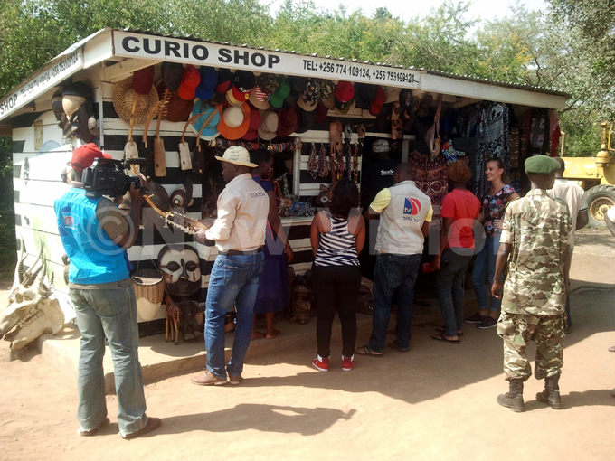  inister of state for tourism odfrey iwanda tastes a music instrument sold in the buro ational ark curio