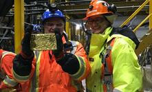 TMAC Resources' president, Gordon Morrison, and CEO Catharine Farrow holding the first gold bar poured at Hope Bay