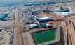 An aerial shot of the concentrator with the run-of-mine stockpile in the background.