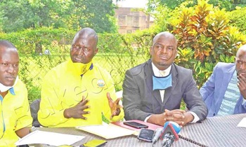 Achile (owookubiri ku kkono) ng’ayogera eri bannamawulire. Asooka ku kkono ye Kyomya ate owookubiri ku ddyo ye Mandera Nsubuga. Achile (owookubiri ku kkono) ng’ayogera eri bannamawulire. Asooka ku kkono ye Kyomya ate owookubiri ku ddyo ye Mandera Nsubuga.