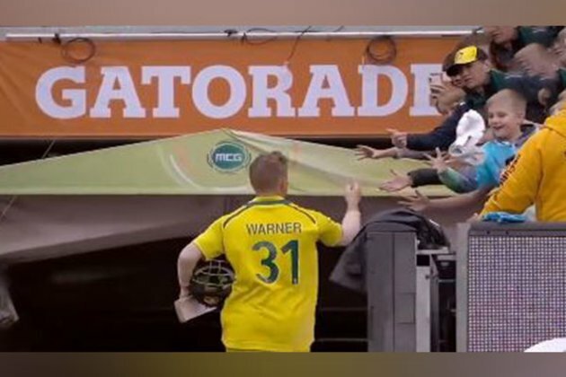 David Warner gives his pair of gloves to a child after scoring century
