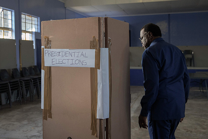 amibia incumbent resident and amibia ruling party outh est frica eoples rganization  presidential candidate age eingob enters a voting booth to electronically mark his vote  hoto