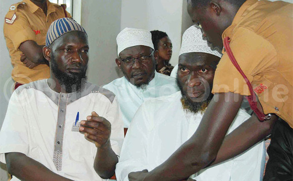 Omuserikale w’amakomera ng’aggya empingu ku Sheikh Fahad Kalungi ne Sheikh Siraje Kawooya. Omuserikale w’amakomera ng’aggya empingu ku Sheikh Fahad Kalungi ne Sheikh Siraje Kawooya.
