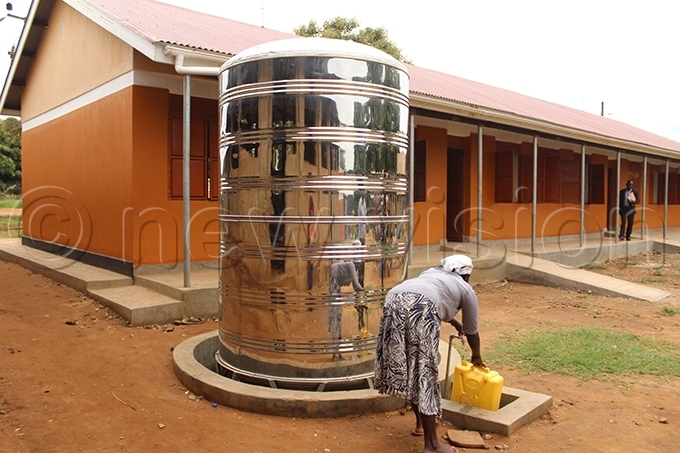  woman draws water from a water tank installed on one of the newly constructed classroom blocks at iyaye rimary chool hoto by eoffrey utegeki