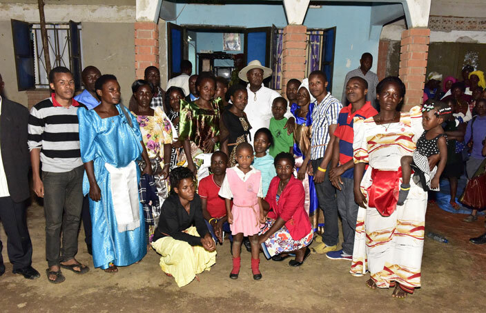  resident useveni in hat possess for a photo with the bereaved family members of the ate amuel ajyambere who was killed over a land wrangle 