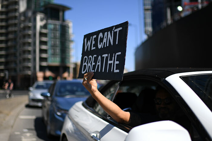 sign displaying the message e ant reathe is held out of a car window as demonstrators make their way towards the mbassy in central ondon on ay 31 2020 to protest the death of eorge loyd hoto by