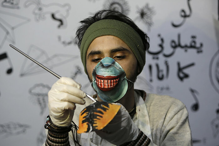 alestinian artist orgham rakeh paints an 95 protective mask for a project raising awareness about the 19 coronavirus pandemic in aza ity on arch 24 2020 hoto by