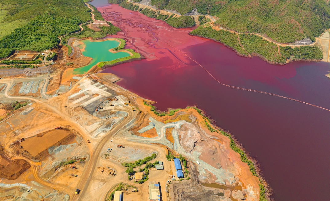 Aerial view of turquoise and maroon water lake in nickel mine. Mindanao, Philippines.