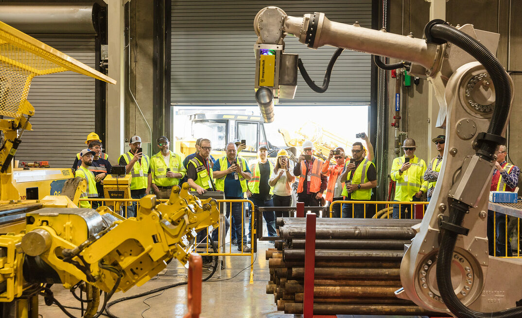 Guests at the Major Drilling USA workshop viewing a new high-powered magnetic hands-free robotic rod handler affixed to a Smart 8 underground drill