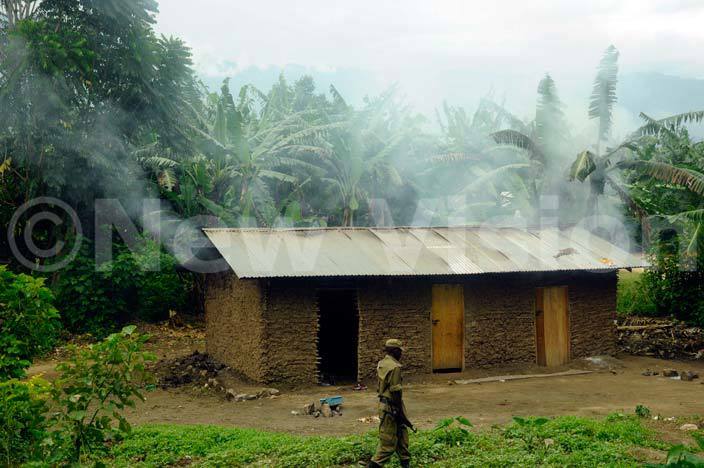 moke spews from a burnt house  set on fire by attackers in iremya illage undibugyo district