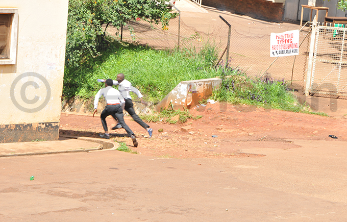 tudents run for cover after olice fire teargas hoto by arim sozi