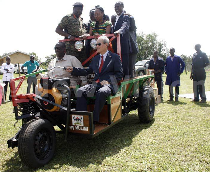 mb  ali and en aleh test drive the  ulimi tractor during its launch at abanyolo hoto by yet kwera