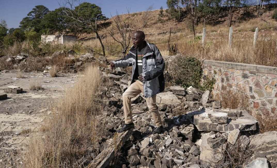 Sibusiso Khumalo from the West End Mining and Rehabilitation Trust walking over the rubble of a home that was demolished at the Waterpan Village.