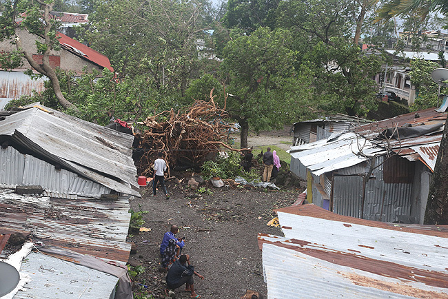  eople stand by damaged houses and fallen trees on hursday in oroni after tropical storm enneth hit omoros before heading to recently cycloneravaged ozambique 