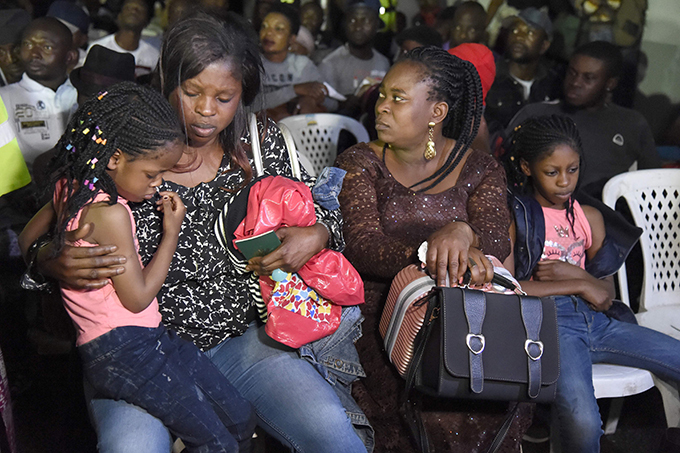  family among a first group of igerians repatriated from outh frica following xenophobic violence sits together after arriving in agos  hoto