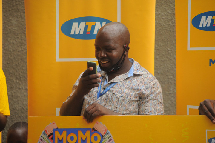 An excited Ayebale after receiving his cash prize via Mobile Money