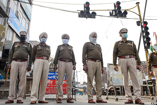  ndian police personnel stand guard at a traffic light during the first day of a 21day governmentimposed nationwide lockdown