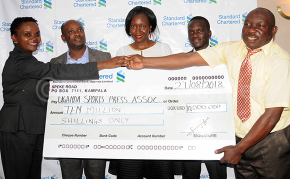 Aba Standrd Chartered Bank nga bakwasa aba USPA ceeke ya bukadde 10 okutegeka emikolo gy'okujjukira bannamawulir eabaafiira mu kabenje e Lugazi n'okulwanyisa obubenje mu ggwanga. Okuva ku ddyo ye pulezidenti wa USPA Sabiiti Muwanga. Addiriddwa Joshua Bagatya akuira abayizi mu ttendekero lya Buganda Royal Insititute, Rita Aliguma omumyukawa pulezidenti wa USPA, Regina Mukiri owa Standard Charterred Bank ne Michael Mukundane omukwanaganya mu kitongole ekiddukanya okusolooza n'okuganba omusaanyi. Babadde ku kitebe kya bank eyo mu Kampala. (Ekif:Silvano Kibuuka) Aba Standrd Chartered Bank nga bakwasa aba USPA ceeke ya bukadde 10 okutegeka emikolo gy'okujjukira bannamawulir eabaafiira mu kabenje e Lugazi n'okulwanyisa obubenje mu ggwanga. Okuva ku ddyo ye pulezidenti wa USPA Sabiiti Muwanga. Addiriddwa Joshua Bagatya akuira abayizi mu ttendekero lya Buganda Royal Insititute, Rita Aliguma omumyukawa pulezidenti wa USPA, Regina Mukiri owa Standard Charterred Bank ne Michael Mukundane omukwanaganya mu kitongole ekiddukanya okusolooza n'okuganba omusaanyi. Babadde ku kitebe kya bank eyo mu Kampala. (Ekif:Silvano Kibuuka)