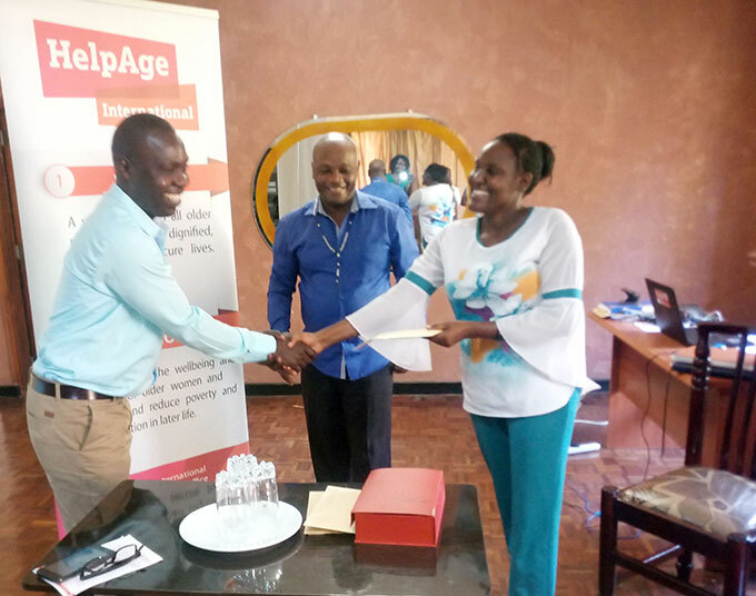  mily emigisha the national programme coordinator elp ge nternational handing over a cash prize of sh550000 to phraim asozi of the aily onitor at the head offices in tinda