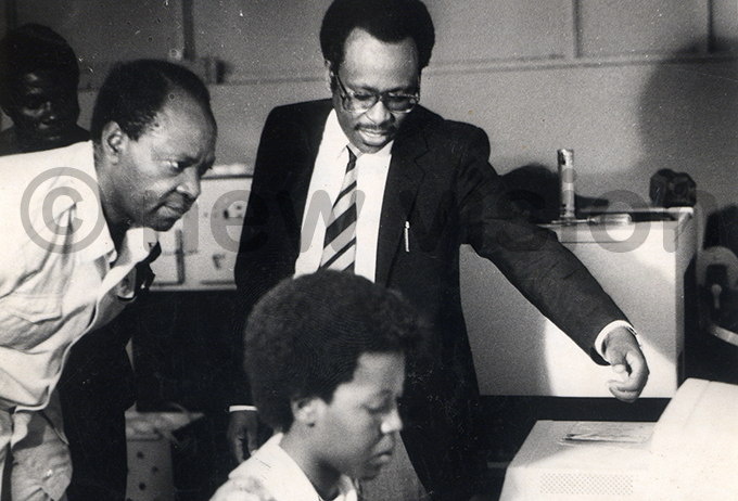 ames umusiime centre showing the then deputy minister of information aumbe ukwana the newspapers typesetting machine