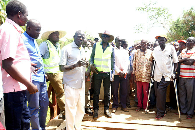   fficials led by ngineer illiam manya third left with  ganda econd left listening to the locals during the handover of azi bridge in goko for construction hoto by obert riaka