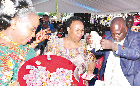 Maama Fiina yatunudde n’asoberwa ng’omugagga Butebi asuula doola ate nga ye agaba bwa 20,000/-. Ku kkono ye mugole Resty Nakanaabi gwe baabadde basuulira ssente. Mu katono ze ssente omugole ze baamuwadde. Maama Fiina yatunudde n’asoberwa ng’omugagga Butebi asuula doola ate nga ye agaba bwa 20,000/-. Ku kkono ye mugole Resty Nakanaabi gwe baabadde basuulira ssente. Mu katono ze ssente omugole ze baamuwadde.