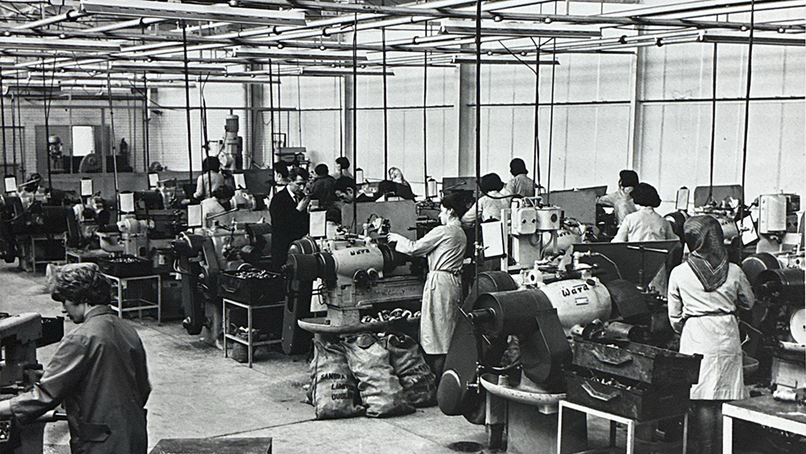 Instantor staff machining brass plumbing fittings on manual lathes.