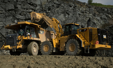 A Cat 988K XE electric drive wheel loader loads a Cat 775G truck