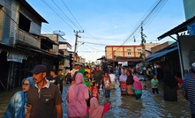 Aceh, Indonesia - November 25, 2025: Flooded neighbourhood market with residents navigating the high water.