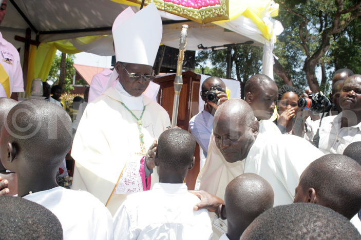  he ishop meritus of ugazi atholic diocese r athias sekamanya confirming some of the children at the function